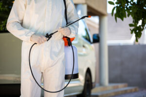 Mid section of pest control man standing next to a van on a street